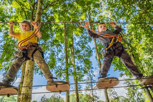 Twee kleine jongens in een touwpark Actieve fysieke recreatie van het kind in de frisse lucht in het park Training voor kinderen