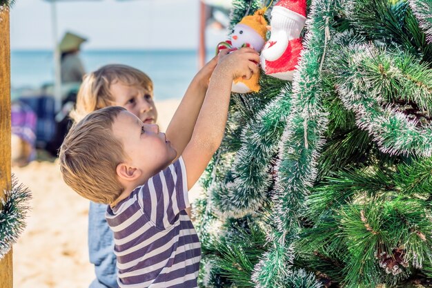 Twee kleine jongens met kerstmis op het strand