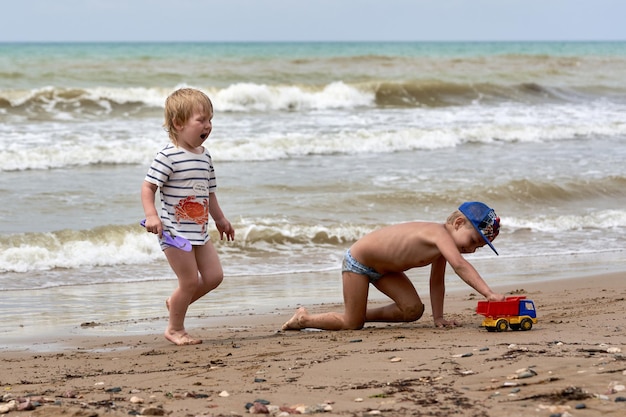 Twee kleine jongens spelen aan de kust