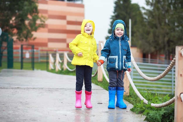 Twee kleine kinderen, jongen en meisje kijken naar apenshow in de dierentuin op een koude herfstdag Kinderen kijken naar dieren in safariparkxA