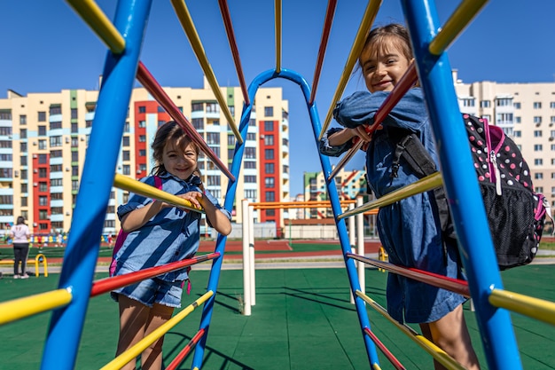 Twee kleine meisjes, basisschoolleerlingen, spelen na school op de speelplaats.