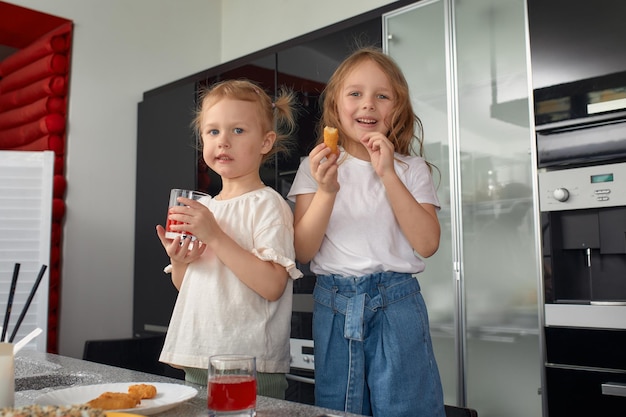 Twee kleine meisjes, broers en zussen die plezier hebben en thuis in de keuken eten met Japans eten