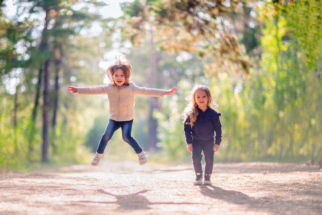 Twee kleine meisjes die buiten springen