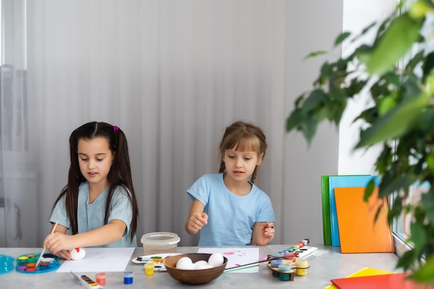 twee kleine meisjes met penseel schilderen op tafel, onderwijs, aquarel, tekenen, creativiteit concept.