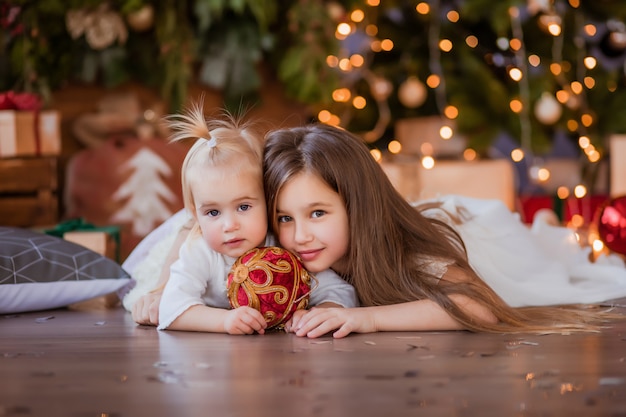 twee kleine meisjes naast de kerstboom