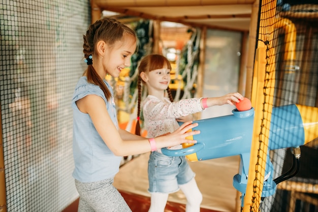 Twee kleine meisjes spelen luchtpistool in game center