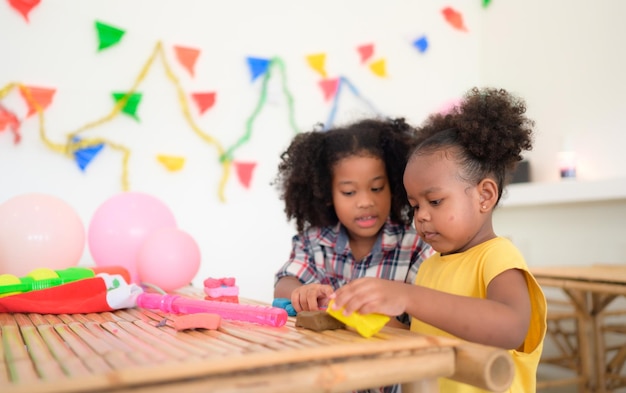 Twee kleine meisjes spelen met plasticine.