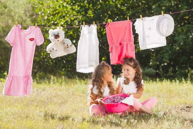 Twee kleine meisjes wassen. Zusters doen huishoudelijk werk