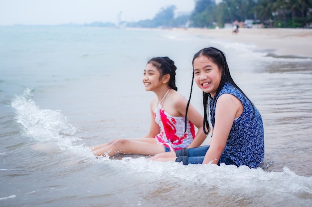 Twee kleine meisjes zijn op het strand.