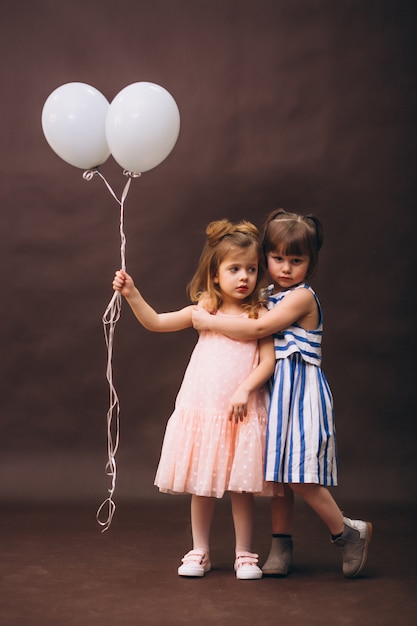 Twee kleine meisjesmodellenstudio met ballons