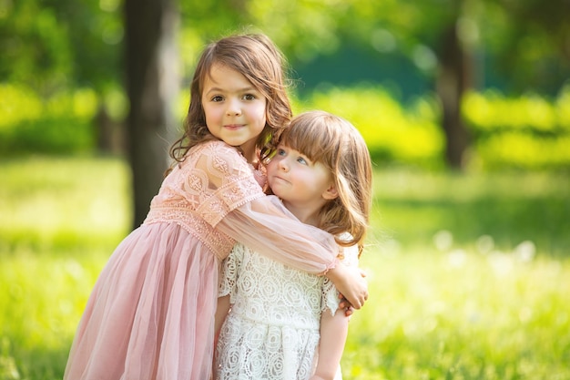Twee kleine mooie meisjes kinderen samen gelukkig spelen en lachen in de natuur
