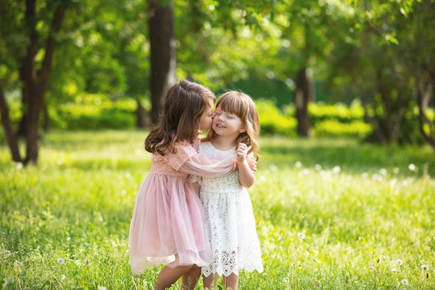 Foto twee kleine mooie meisjes kinderen samen gelukkig spelen en lachen in de natuur