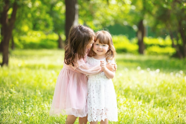 Foto twee kleine mooie meisjes kinderen samen gelukkig spelen en lachen in de natuur