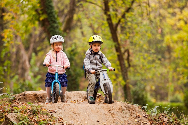 Twee kleine vrienden die op balanceerfietsen zitten