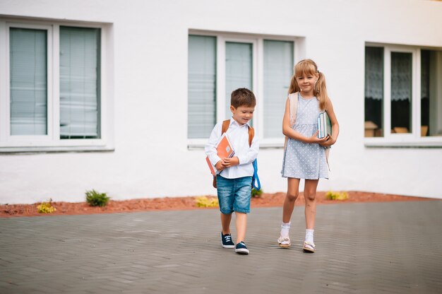 Twee kleine vriendjes gaan naar school. schoolkinderen. terug naar school