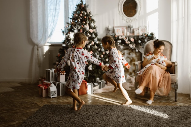 Twee kleine zusjes in pyjama plezier nieuwjaarsboom met cadeaus