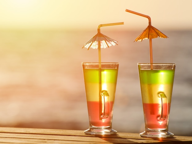 Twee kleurrijke cocktails in de zonsondergang