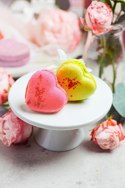 Twee kleurrijke hartvormige bitterkoekjes op wit staan close-up Concept van zoete tafel voor trouwdag