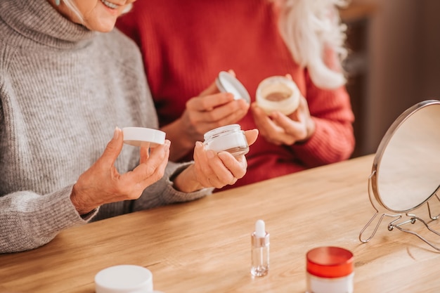 Twee knappe oudere vrouwen met nieuwe crèmes