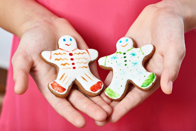 Foto twee koekjes van de peperkoekmens van kerstmis in handen