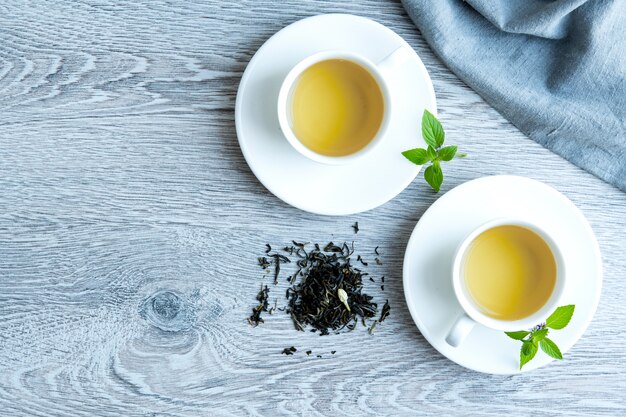 Twee kopjes groene thee op een grijze tafel