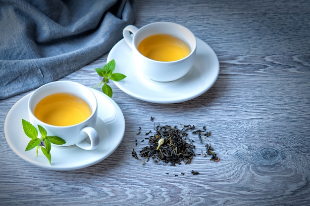 Twee kopjes groene thee op een grijze tafel