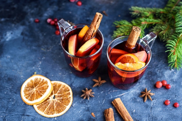 Twee kopjes kerst glühwein of gluhwein met kruiden en stukjes sinaasappel op rustieke tafel bovenaanzicht. Traditioneel drankje op wintervakantie. Nieuwe jaar inhoud