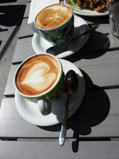 Foto twee kopjes koffie geserveerd op een tafel.