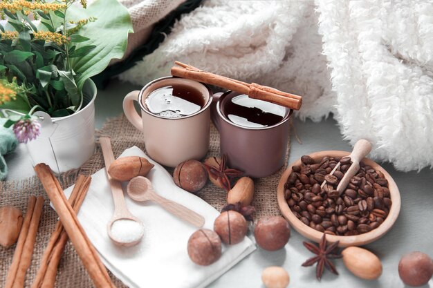 Twee kopjes koffie met macadamianoten en kaneel op een achtergrond van dekens