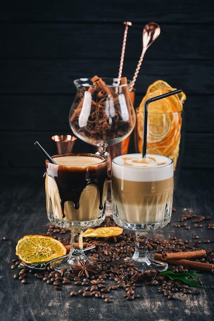 Twee kopjes koffie met melk en room Op een zwarte houten achtergrond Bovenaanzicht Kopieer de ruimte