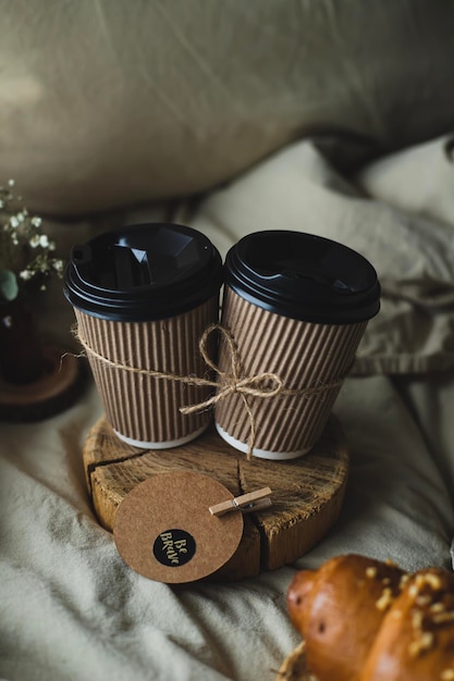 Twee kopjes koffie op een houten tafel met een label met hh