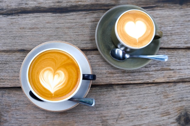 Twee kopjes koffie op houten ondergrond met prachtige latte art