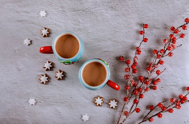 Twee kopjes koffie op witte tafel met rode bessen tak