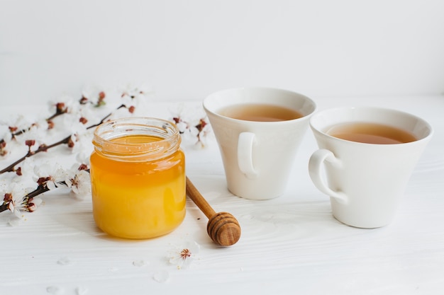 Foto twee kopjes thee en honing op houten achtergrond