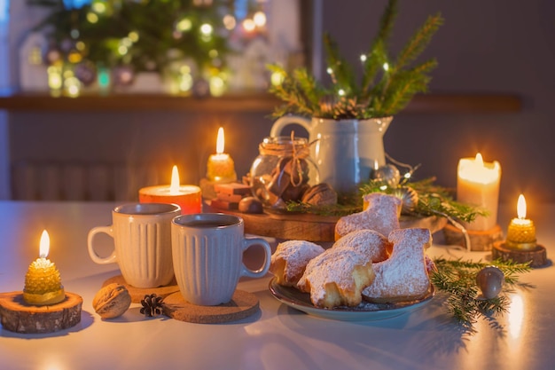 Twee kopjes thee met zelfgemaakte kerstgebakken goederen op keuken met kerstversiering