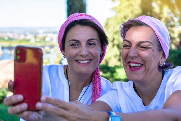 Twee Lachende Jonge Volwassen Vrouwen Met Een Roze Hoofddoek Nemen Een Selfie.