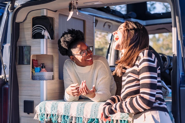 Foto twee lachende vrouwen in een gesprek in een camper