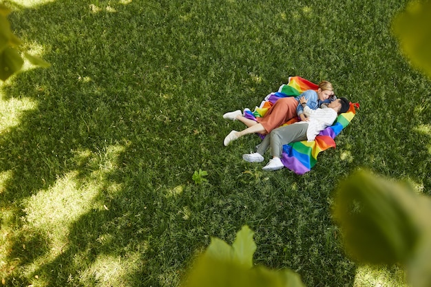 Twee lesbiennes liggen op groen gras en genieten van elkaar buiten in het park