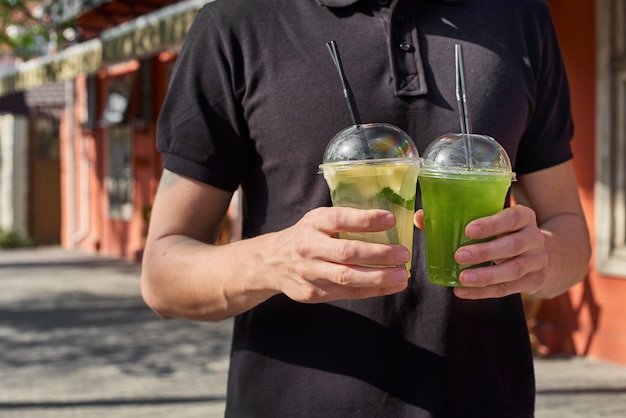 Twee limonade in handen van de man. verse komkommer en citroendranken.