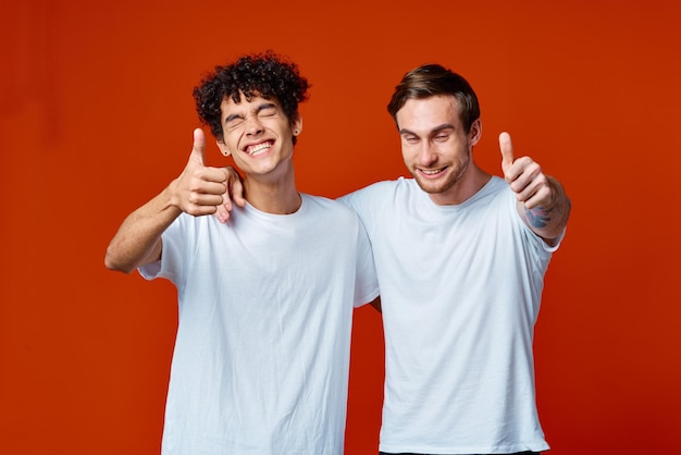 Foto twee man in witte t-shirts pret emoties handgebaren vriendschap knuffels