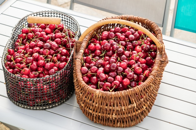 Twee manden gevuld met prachtige rode kersen op een tuintafel