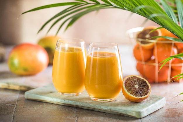 Twee mango lassi of kesar melk in glazen Indiase gezonde ayurvedische koude drank met mango Versheid lassi gemaakt van yoghurt, water, kruiden, fruit en ijs