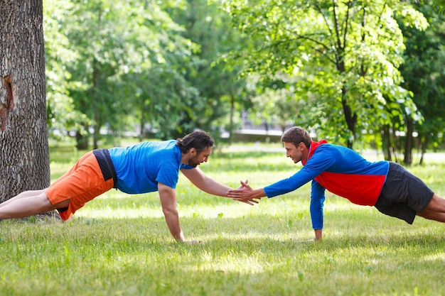 Twee mannen doen push-up in openbaar park en geven vijf