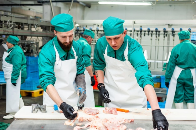 Twee mannen in groene scrubs werken in een fabriek.