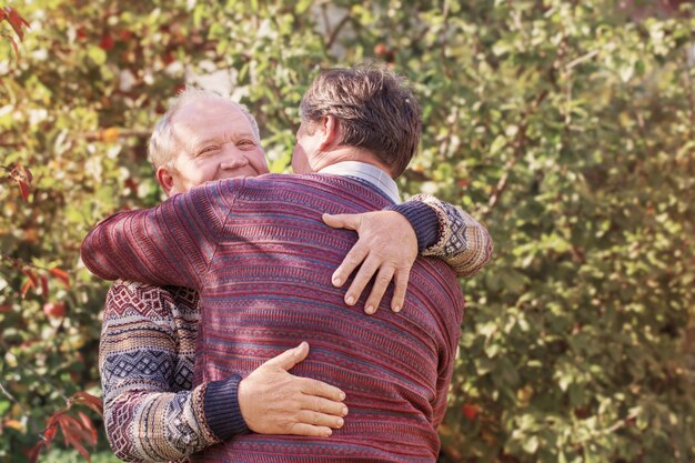 Twee mannen knuffelen in herfst park