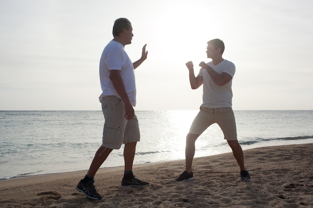 Twee mannen met bokstraining op het strand