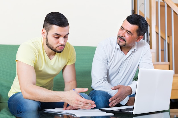 Twee mannen met laptop thuis