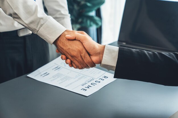Twee mannen schudden elkaar de hand boven een document met de tekst 'businessplan'