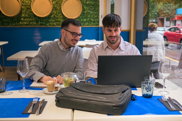 Twee mannen werken op afstand samen vanuit een restaurant