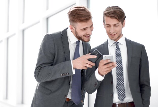 Twee medewerkers bespreken mediabestanden op hun smartphonemensen en technologie